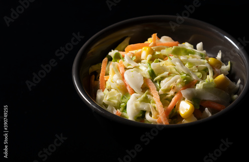 Coleslaw placed on a pitch-black background