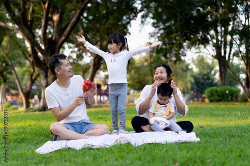 Multi generation people in asian family life are sing a song and dance together for picnic time in the green park with happy moment, concept of love, relation and outdoor activity. © Sukjai Photo