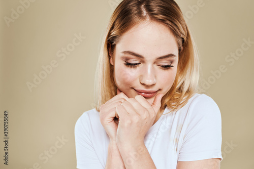 Pretty woman fun white t-shirt emotions beige background cropped view