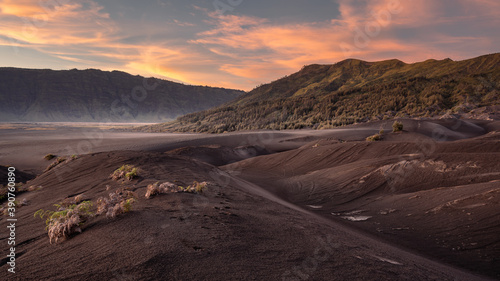 Bromo National Park, East Java, Indonesia - October 16, 2020 : View on the sand sea of Mount Bromo at sunrise with a colorful sky