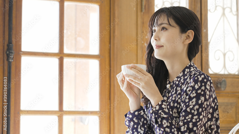 カフェで飲み物を飲む若い女性