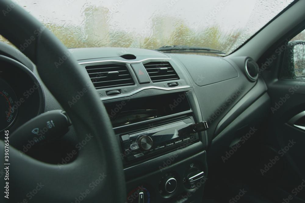 The interior of the car of budget class . It's raining outside .