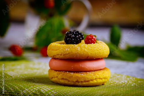 Delicious lemon cookie with pink cream and fresh blackberry.