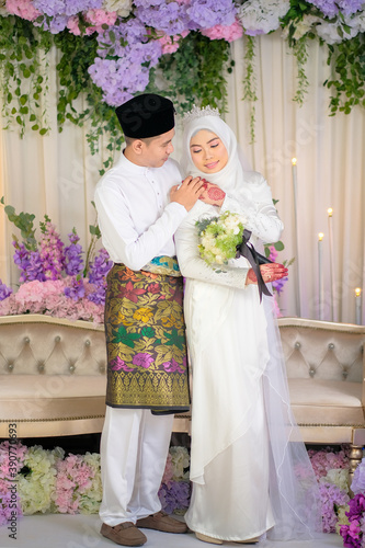 Indoor shooting for Malay wedding, the bride and groom wearing Malay traditional  cloth in marriage ceremony . Happy & Family Concept.