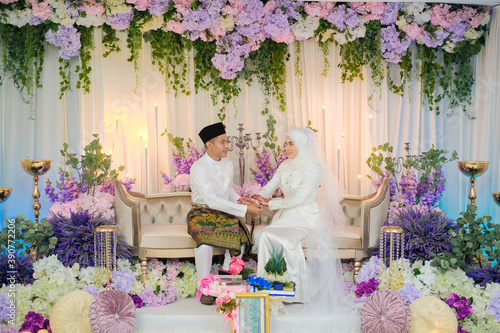 Canvas Print The groom put the wedding bracelet to the bride during solemnization ceremony