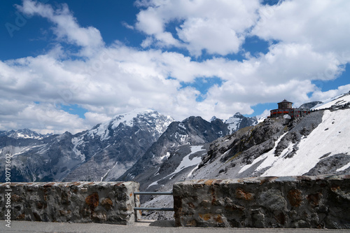 Summer Stelvio pass with alpine road and snow on slope. Panoramic view of the over the alps between Lombardy and Trentino. Color image. Italian mountains.