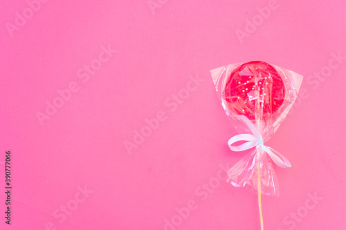 Round pink Lollipop wrapped with a bow top view with space for text. Flatly. Copy space