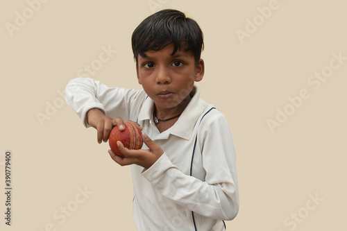 Photography A boy in cricket uniform peppered bowling motion