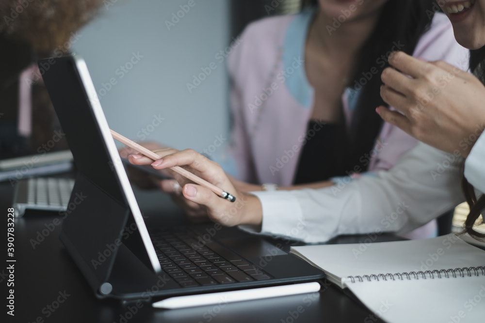 Cropped shot of businesswoman is talking and discussing with her friend while working with computer tablet in modern office. Cropped shot of businesswoman is talking and discussing with her friend while working with computer tablet in modern office.