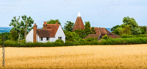 Tableau sur toile Landcape of a traditional English country house on the fields in Kent, England,