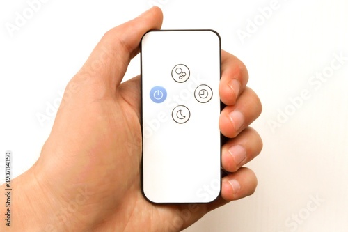 Wallpaper Mural Remote control for controlling the air humidifier in the hand.  Remote control in hand on isolated white background Torontodigital.ca