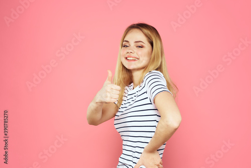 Cheerful woman striped t-shirt lifestyle emotions and gestures with hands pink background