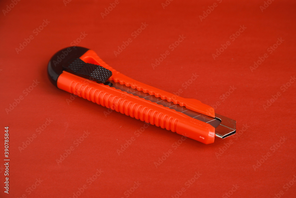 Red cutter knife on red background, sharp knife stationery Red cutter knife on red background, sharp knife stationery