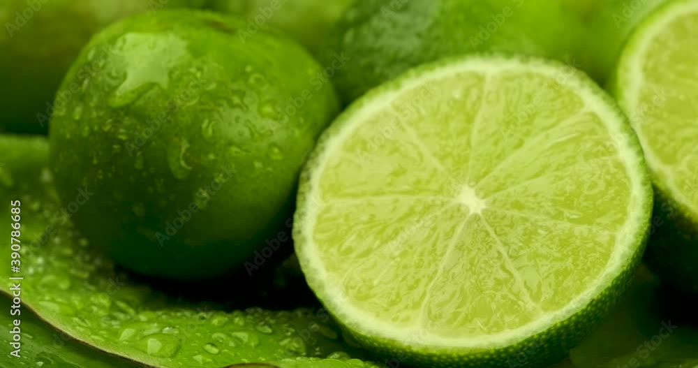 Truck shot close up of half and whole fresh lime juicy on green banana leaves with clearly water drop on surface Truck shot close up of half and whole fresh lime juicy on green banana leaves with clearly water drop on surface