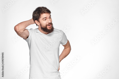 Bearded man in white t-shirt gesture with hands emotions light background