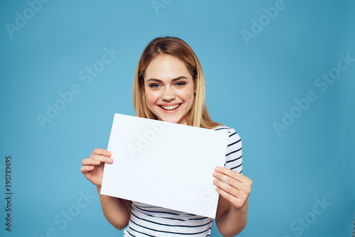 Emotional woman holding a sheet of paper in her hands lifestyle close-up blue background Copy Space