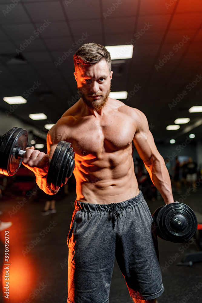 Fit young man lifting dumbbells doing workout at a gym. Sport, fitness, weightlifting, bodybuilding, training, athlete, workout exercises concept. Fit young man lifting dumbbells doing workout at a gym. Sport, fitness, weightlifting, bodybuilding, training, athlete, workout exercises concept.