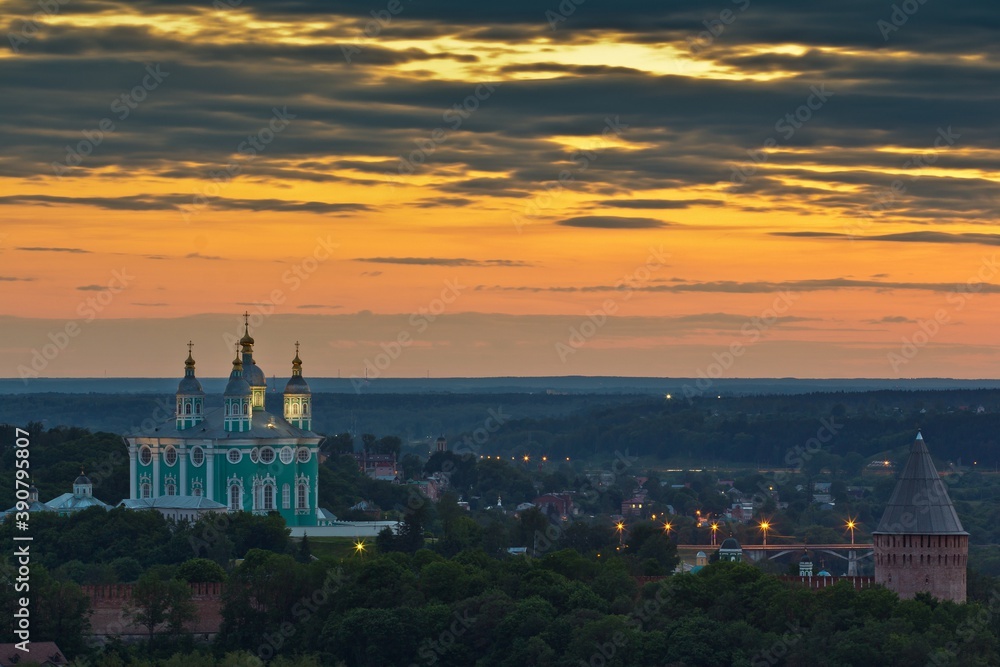 Panoramic view of Smolensk city at sunset: the Cathedral of Assumption over the buildings and the Kremlin and orange sky with clouds in Russia.