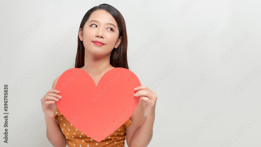 Attractive young smiling woman holding big red heart in hands isolated on white background. Attractive young smiling woman holding big red heart in hands isolated on white background.