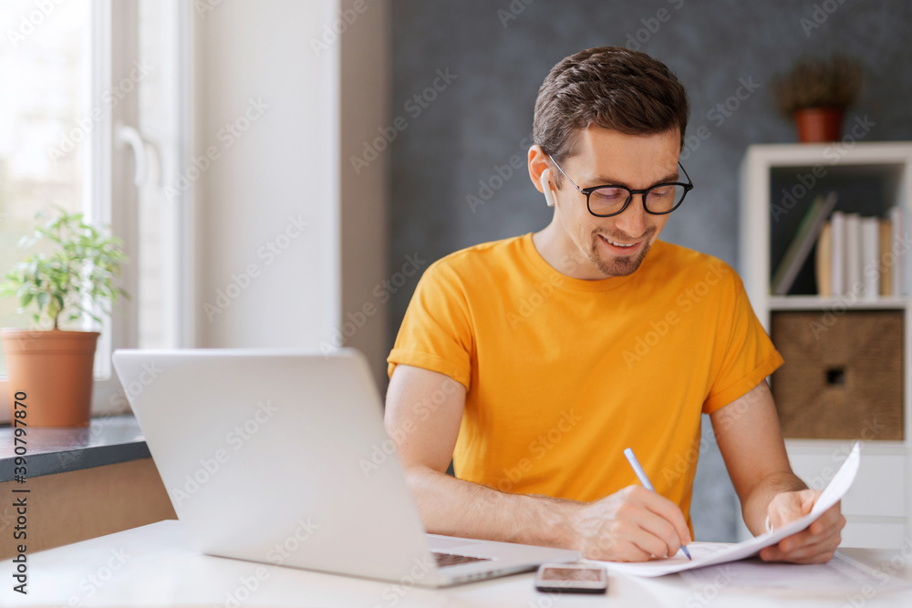 Smiling guy student wearing wireless headphone study online with skype teacher, has online class. Happy young man learn language, listen lecture, watch webinar, write notes. Distant education concept Smiling guy student wearing wireless headphone study online with skype teacher, has online class. Happy young man learn language, listen lecture, watch webinar, write notes. Distant education concept