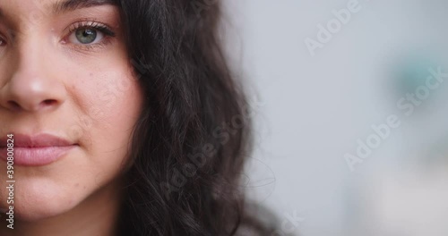 Close-up of half woman face with perfcet skin and light nude make-up. Fascinating female grey eyes with shiny green shadow. photo