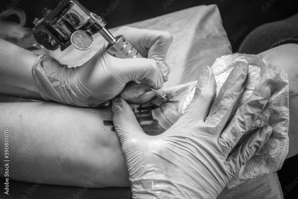 Tattooer doing tattoo in a workshop studio