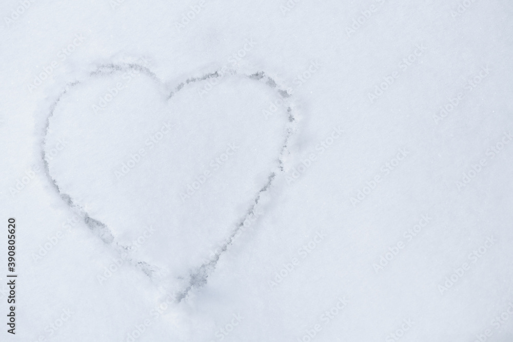One heart in the snow. A heart is drawn on the snow close-up. The shape of heart on the snow. Winter background..