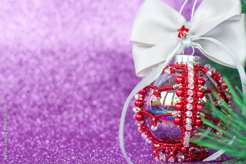Beautiful and very shiny bead. Toy for the Christmas tree. Christmas balloon on a purple background. New year greetings, postcards, calendar.