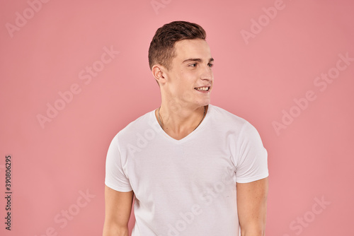 Emotional man gesturing with his hands white t-shirt pink isolated background