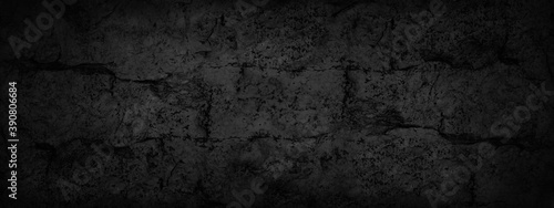 Black background. Old cracked wall texture. Dark grunge background. Web banner with rough texture.