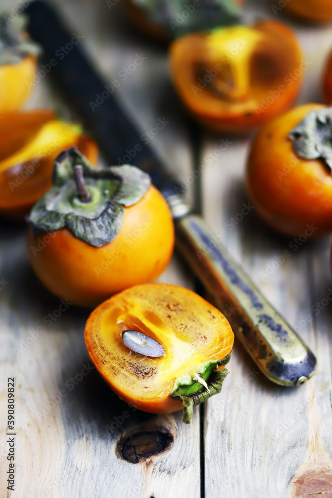 Persimmon on a wooden surface. Persimmon in the cut. Autumn fruits. Persimmon on a wooden surface. Persimmon in the cut. Autumn fruits.