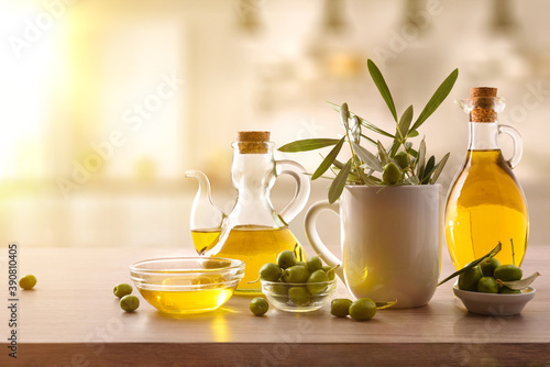 Virgin olive oil and harvest olives on kitchen bench