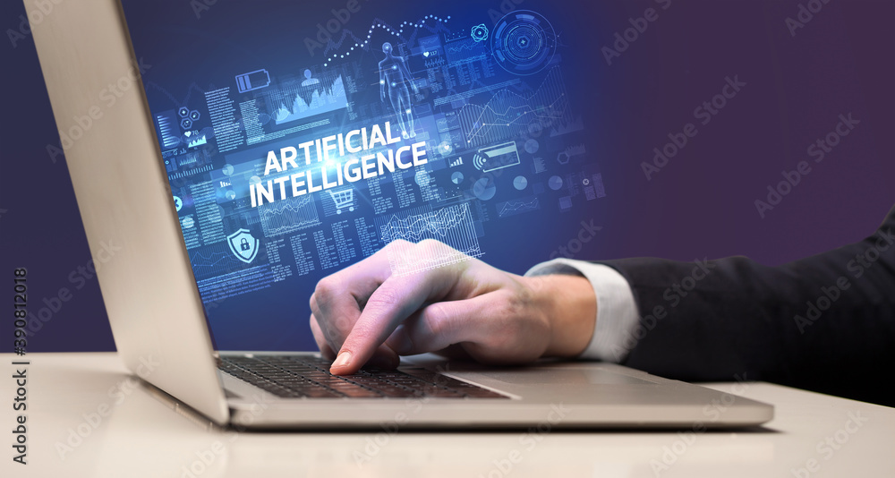 Businessman working on laptop with ARTIFICIAL INTELLIGENCE inscription, cyber technology concept Businessman working on laptop with ARTIFICIAL INTELLIGENCE inscription, cyber technology concept