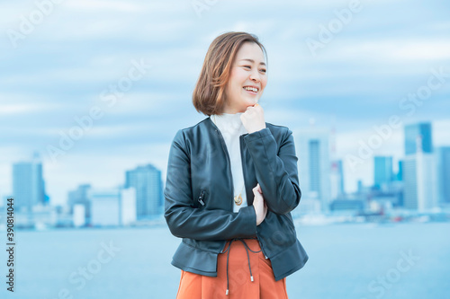 屋外で笑顔を見せるオフィスカジュアルスタイルの女性