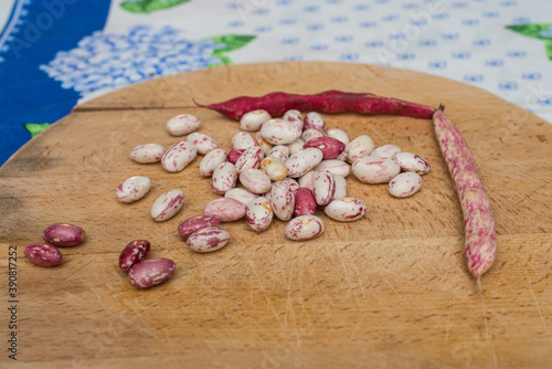 Borlotti beans peeled on wooden cutting board.