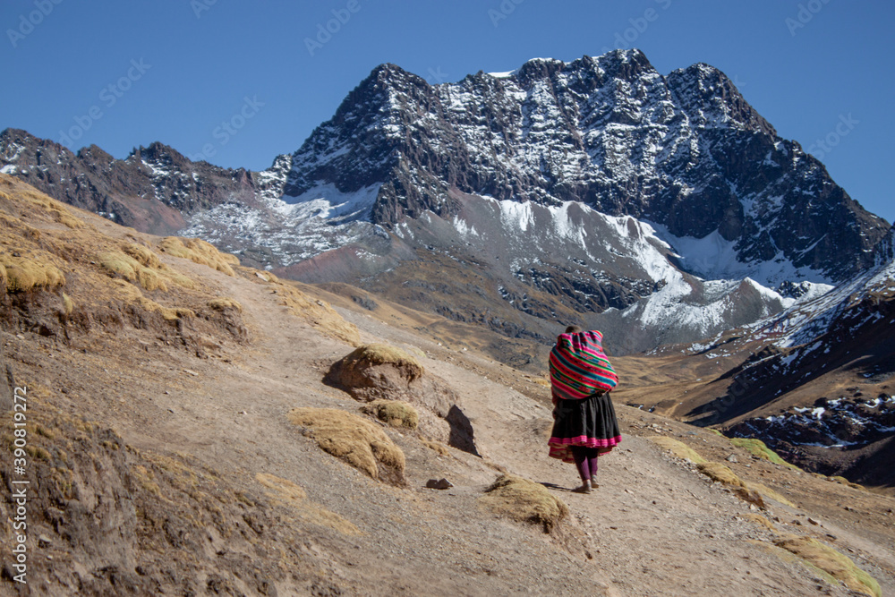 A native lady hiking near the mountains inside the winicunca park near the city of cusco- Peru