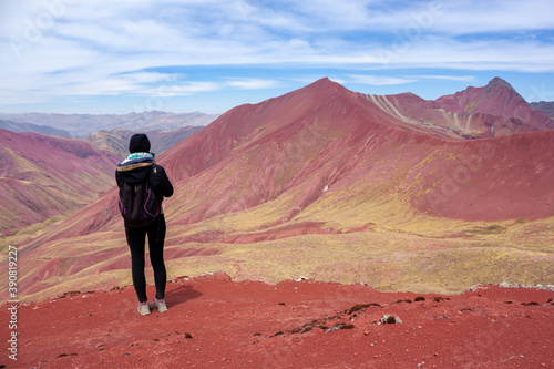 A woman enjoying the view of the red mountains near the rainbow mountain   winicunca   near the city of cusco - Peru