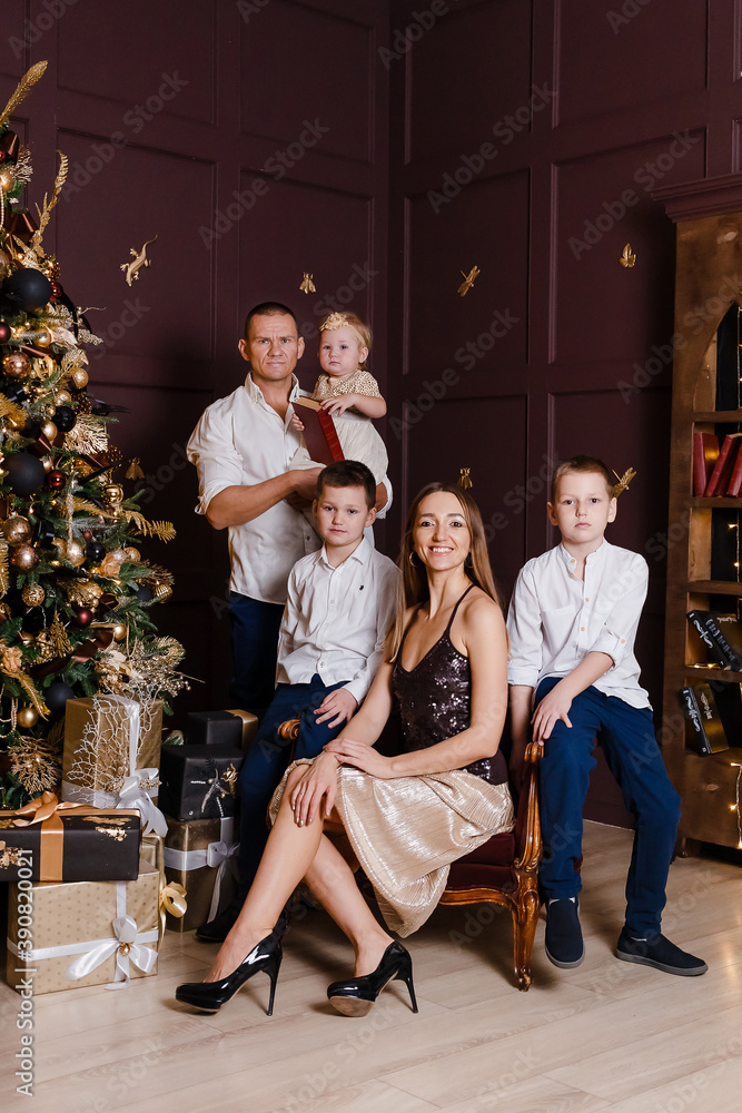Fototapeta premium stylish beautiful family in smart clothes at the New Year photo shoot. dark studio design.