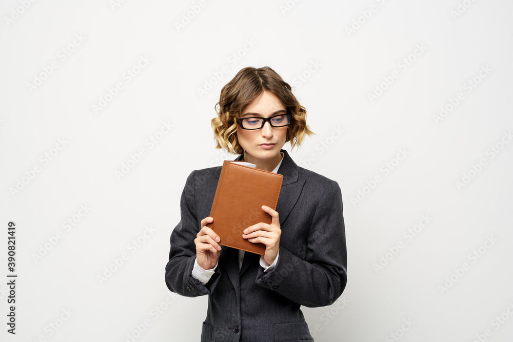 Business woman with notepad and glasses work light background cropped view of suit model. Business woman with notepad and glasses work light background cropped view of suit model.