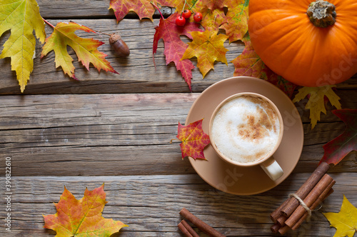 Autumn composition - cappuccino, autumn leaves and pumpkin on wooden background © udra11