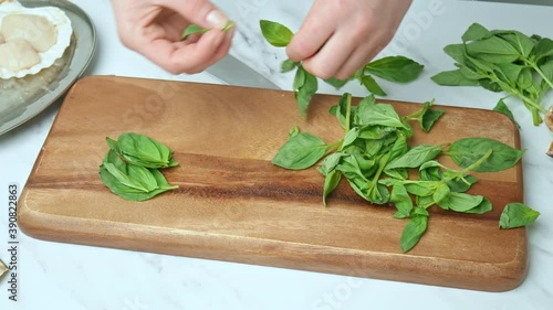 A close-up look of chopping and sorting basil leaves on a cutting board in 4K.