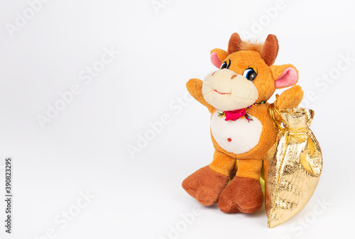 Children's soft toy bull with a bag of gifts, isolate on a white background. Cute toy for children's games. Symbol of the new year 2021. Copy space. Mock up