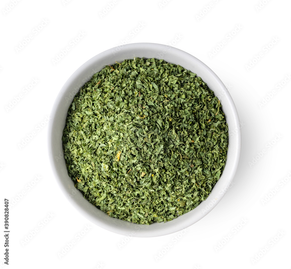 Dried parsley in a white bowl on a white background Dried parsley in a white bowl on a white background