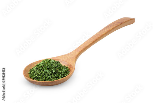 Dried parsley in wood spoon on a white background