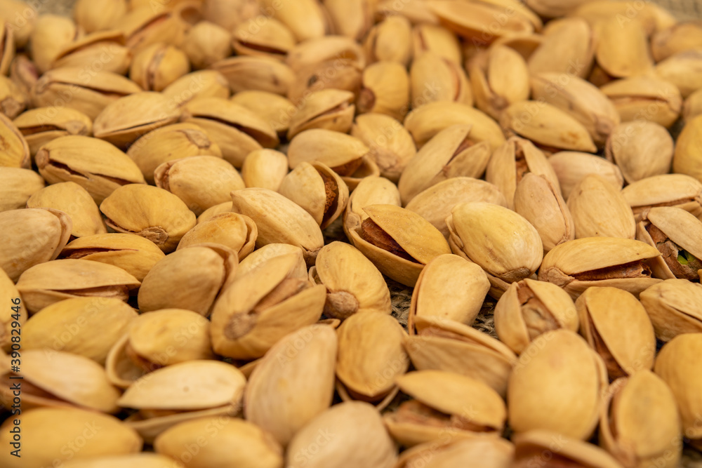 Salted pistachios lie on the burlap. Close up.