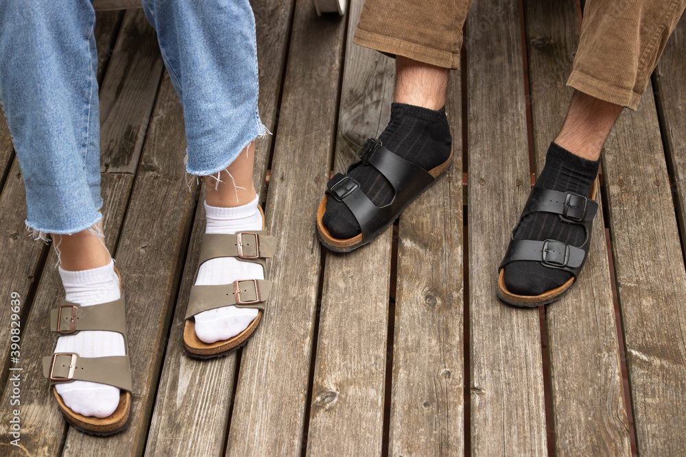 Guy in black socks and girl in white socks on the old wooden floor. both in  sandals. close-up. Stock Photo | Adobe Stock