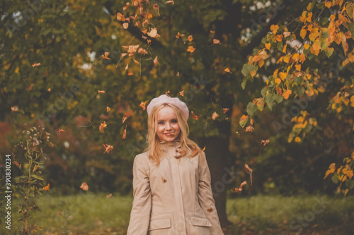Beautiful smiling woman on fall nature background in autumn park