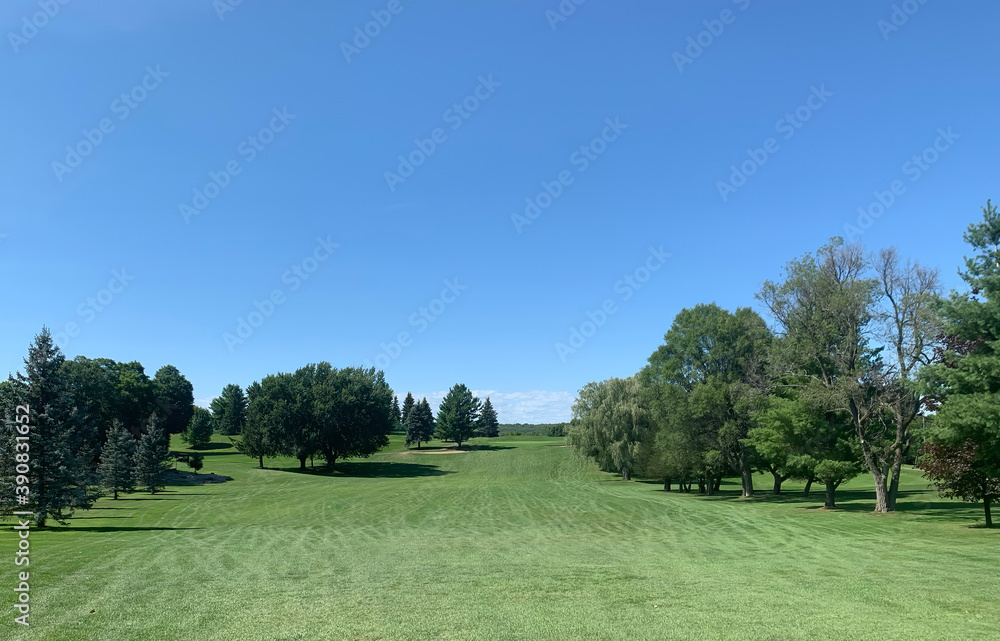 A green golf course and blue sky on a beautiful summer day in Canada
