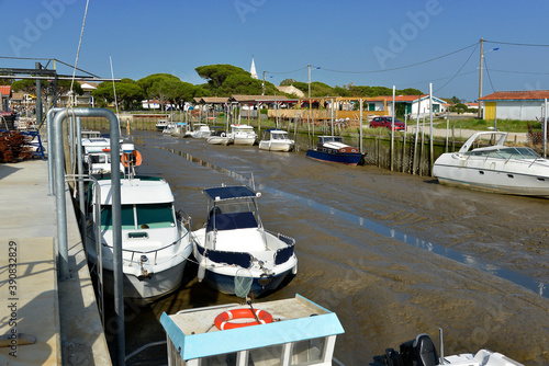 Boats and barge in the ostreicole harbor at low tide of Audenge, commune is a located on the northeast shore of Arcachon Bay, in the Gironde departmentin southwestern France. photo