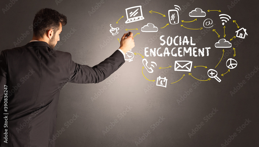 businessman drawing social media icons with SOCIAL ENGAGEMENT inscription, new media concept